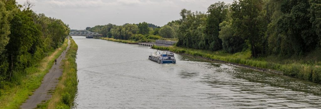 Point de vue sur la future confluence entre le canal de la Sensée et le Canal Seine-Nord Europe avec vue à droite sur le quai travaux d’Aubencheul-au-Bac finalisé – Été 2026 @SCSNE- O et JC Hecquet